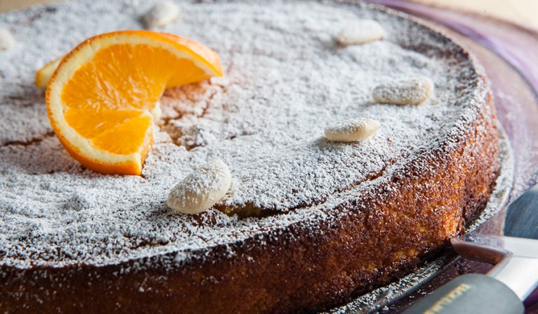 Torta sefardita intera decorate con fetta arancia e mandorle