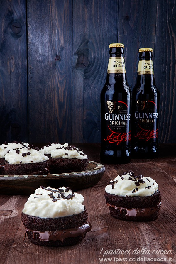 Tortine alla Guinnes ripiene di Nocciolata con glassa al mascarpone e panna con bottiglie sullo sfondo